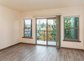 Thumbnail 7 of 8 - A room with a sliding glass door and a wooden floor.