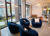 Thumbnail 19 of 23 - a group of blue chairs in a room with large windows