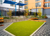 Thumbnail 20 of 23 - a courtyard with benches and grass in front of a building