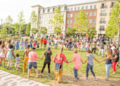 Thumbnail 6 of 6 - A group of people are dancing in a park.