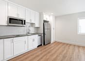 Thumbnail 56 of 65 - Studio Apartment Kitchen including Two-Burner Stovetop,Dishwasher, Full-Size Refrigerator, Microwave, and Plenty of Cabinet Storage