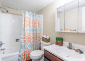 Thumbnail 7 of 36 - Modern bathroom with mirrored three panel medicine cabinet and tub with colorful shower curtain