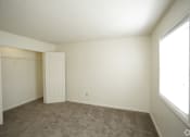 Thumbnail 13 of 36 - Large carpeted bedroom with large closet and window with blinds