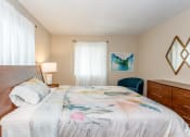 Thumbnail 18 of 36 - Large bed with colorful bedding and a cedar headboard and modern mirror on wall