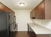 Thumbnail 22 of 36 - Updated kitchen with black appliances and dark wood cabinets and light grey countertop