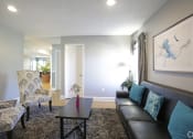 Thumbnail 26 of 36 - large living room with modern black furniture and paintings on the wall with a large area rug and drapes over the windows