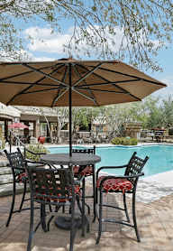 A patio with a table and chairs under an umbrella.