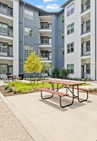 A picnic table sits in front of a mailbox in a courtyard.