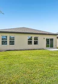 A house with a green lawn in front.