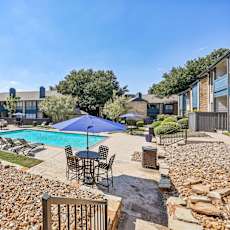 A backyard with a pool and patio furniture.