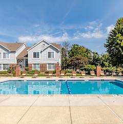 A pool area with a hot tub and lounge chairs.