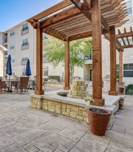 a patio with tables and chairs and a pergola