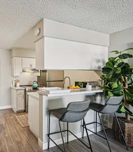 A kitchen with a table and chairs in front of it.