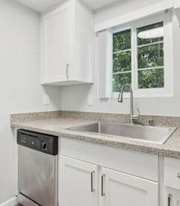A kitchen with white cabinets and a granite countertop.