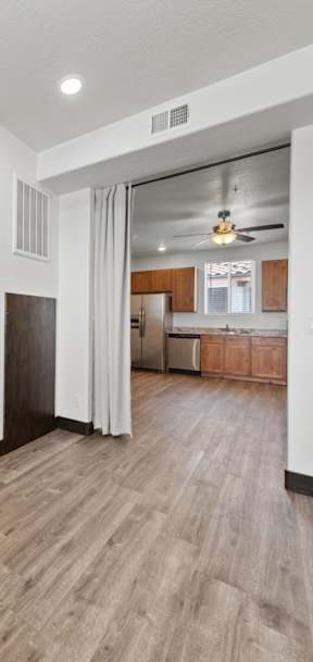A room with a brown carpet and wooden flooring.