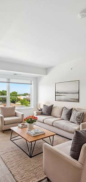 A living room with a couch, chairs, and a coffee table.