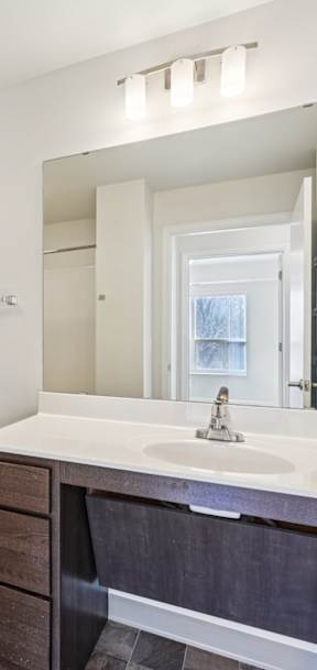 A bathroom with a toilet, sink, and mirror.