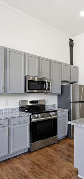 A modern kitchen with a granite countertop and stainless steel appliances.