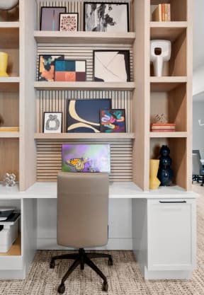 a home office with a desk and shelves