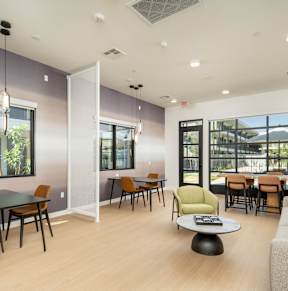 A modern dining room with a glass table and chairs.