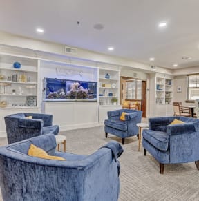 the lobby of a spa with blue chairs and a fish tank