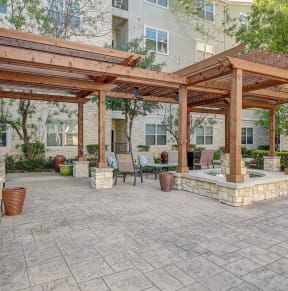 a patio with a pergola and a table and chairs