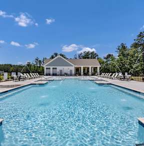 A white house with a pool in front of it.at The Landings at Hard Scrabble, Columbia