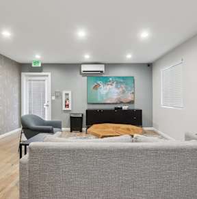 A bedroom with a bed, chair, and painting on the wall.