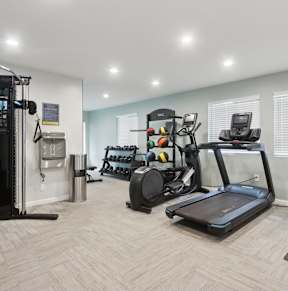 A well-equipped home gym with a variety of exercise machines.