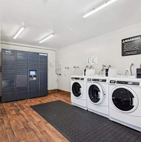 a washer and dryer room with laundry machines and a door to a bathroom