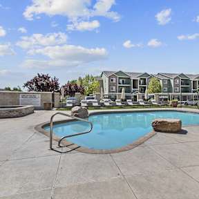 A swimming pool with a rock in the middle of it.