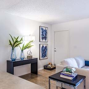 a living room with a couch and a coffee table and a bedroom with a bed
