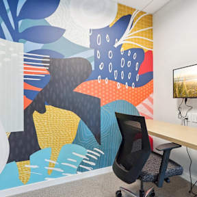 A modern office with a colorful mural on the wall.