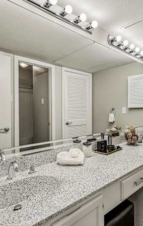 A bathroom with a granite countertop and double sinks.