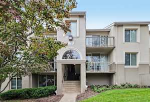 A modern two-story building with a balcony on the second floor.