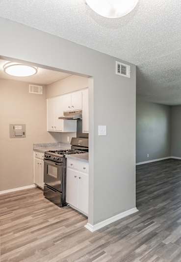 A kitchen with a stove top oven and a refrigerator.