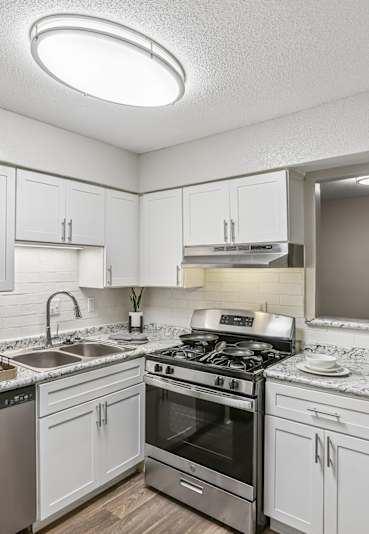 A kitchen with a refrigerator, stove, and sink.