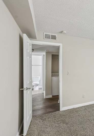 A room with a carpeted floor and a white door.