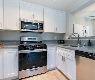 a kitchen with stainless steel appliances and white cabinets