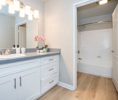 a bathroom with white cabinets and a sink and a mirror