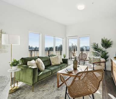 A living room with a green couch and a wooden chair.