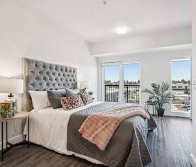 A bedroom with a large bed and a view of the city.