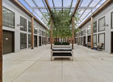 a courtyard with a bench and trees in the middle of it