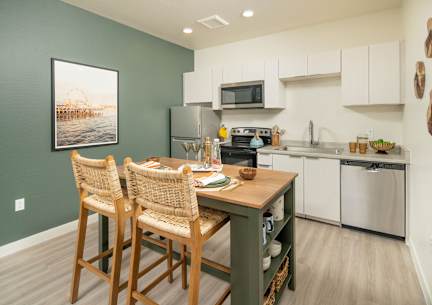 A kitchen with green walls and a wooden table.
