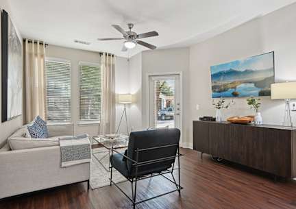 A modern living room with a white couch and a wooden cabinet.