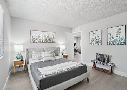 A bedroom with a large bed and two nightstands.