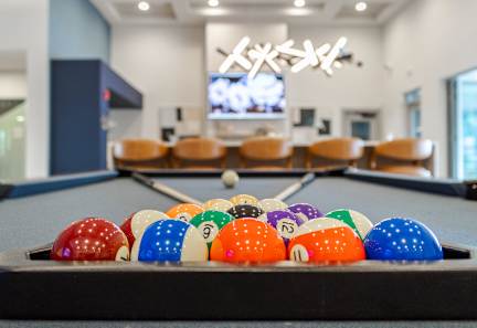 A pool table with a variety of pool balls. at Allure Apartments LLC Apartments, Indiana