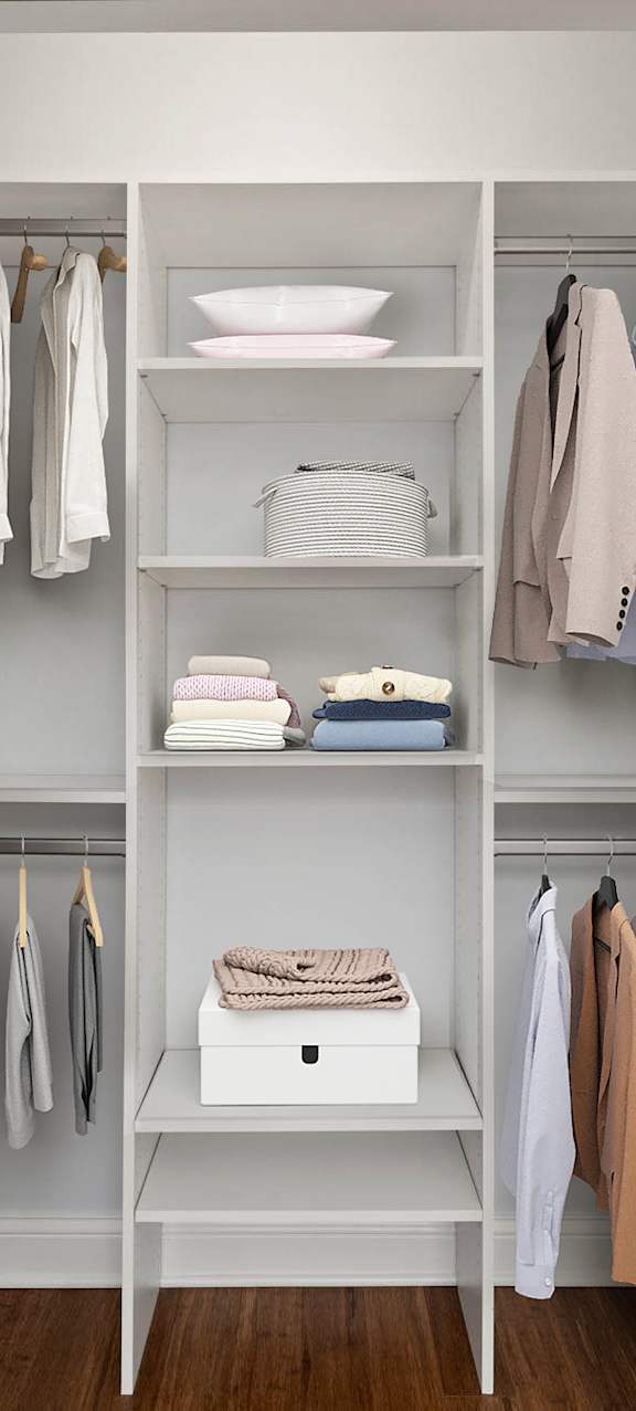 A white closet with clothes hanging and shelves with items.