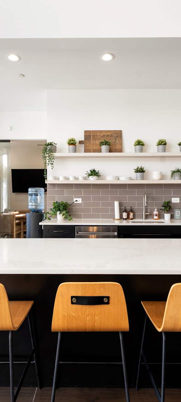 A modern kitchen with a white table and chairs.