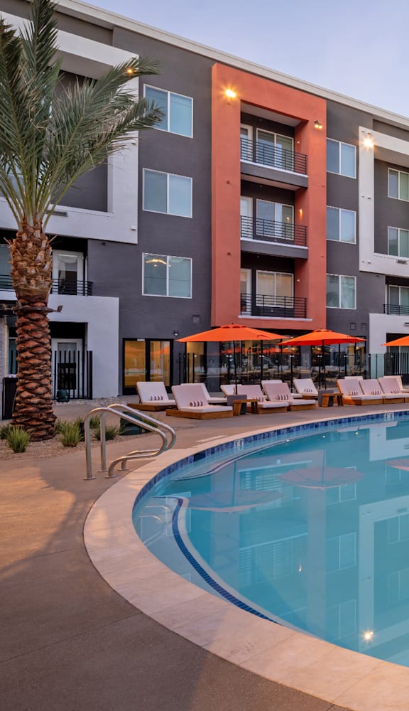 A large swimming pool in front of apartment buildings.
